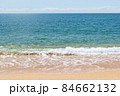 Turquoise sea waves splashing on sand shore 84662132