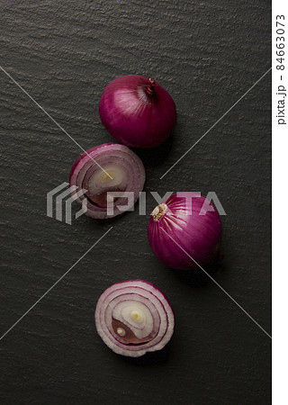 vegetable concept a few half-cut onions being put on the dark background vegetable concept a few half-cut onions being put on the dark background 84663073