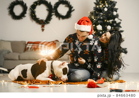 Cute couple sitting at home near christmas tree 84663480