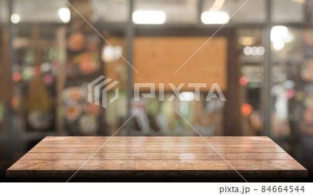 Empty wooden table top with lights bokeh on blur restaurant background. 84664544