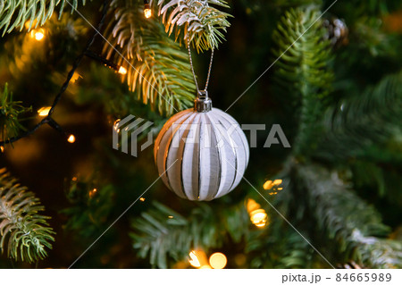 Classic Christmas decorated New year tree. Christmas tree with wite and silver decorations, ornaments toy and ball. Modern classical style interior design apartment. Christmas eve at home 84665989
