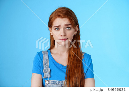 Doubtful questioned girlfriend look camera full disbelief, raise eyebrow frowning confused, hear strange weird nonsense talks, stand blue background, smirk unsatisfied, feel uncomfortable 84666021