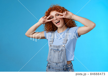 Say cheeze hello summer. Cheerful charming playful charismatic redhead cute girl curly hairstyle show tongue peace victory gesture eyes tilt head joyful mimicking funny attitude happy emotions Say cheeze hello summer. Cheerful charming playful charismatic redhead cute girl curly hairstyle show tongue peace victory gesture eyes tilt head joyful mimicking funny attitude happy emotions 84666473