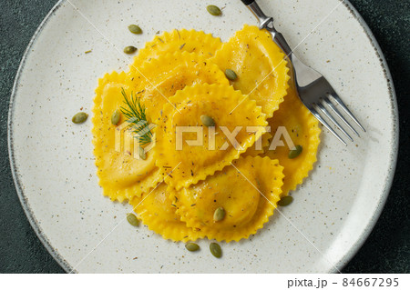 Homemade Pumpkin Ravioli with butter on a dark concrete background. Top view 84667295