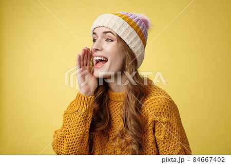 Attractive happy girlfriend shout call boyfriend standing far away take pic, turning left scream hold hand near opened mouth seek friend yelling loudly, search someone, yellow background 84667402