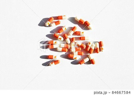 Orange and white capsule pills isolated on white background 84667584