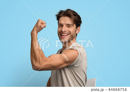 Vaccinated Young Man Demonstrating Biceps With Adhesive Band After Injection Vaccinated Young Man Demonstrating Biceps With Adhesive Band After Injection 84668758