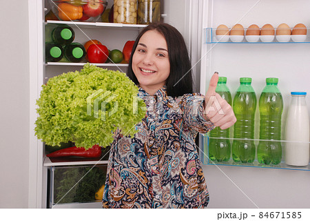 Beautiful young girl near the Fridge with healthy food. 84671585