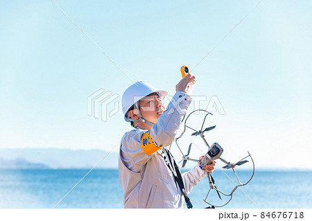 ドローンを操縦する作業員 84676718