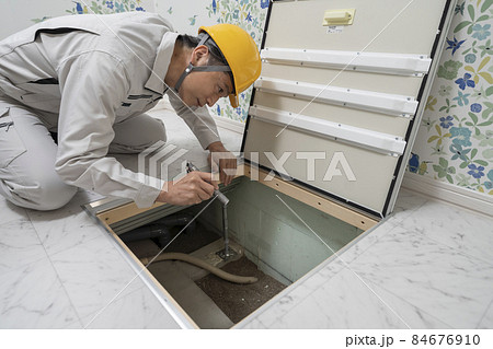 住宅の床下点検口から中を見る作業服の男性 住宅の床下点検口から中を見る作業服の男性 84676910