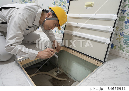 住宅の床下点検口から中を見る作業服の男性 住宅の床下点検口から中を見る作業服の男性 84676911