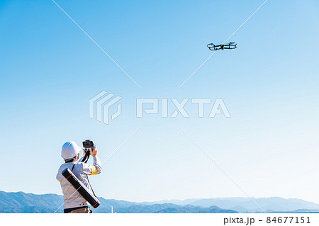 ドローンを操縦する作業員 84677151