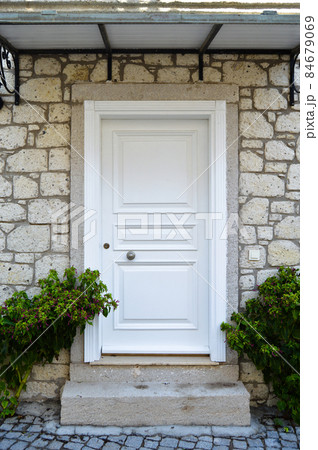 Decorative entrance wooden white door of a nostalgic house in Alacati, Cesme, Izmir, Turkey Decorative entrance wooden white door of a nostalgic house in Alacati, Cesme, Izmir, Turkey 84679069