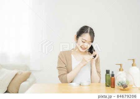 ヘアケア商品を使う女性（笑顔） 84679206
