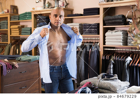 Man trying on shirt in clothing store Man trying on shirt in clothing store 84679229