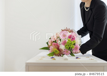 喪服を着た女性が供える棺上花束　エンディングブーケ　シンプルなお葬式　イメージ 84679515