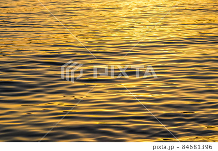 Golden sea waves in sunset glow as surface background. Summer holidays and coastal nature concept Golden sea waves in sunset glow as surface background. Summer holidays and coastal nature concept 84681396
