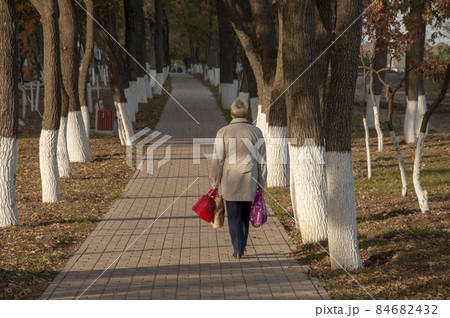 Unrecognizable woman in a grey coat and with packages Unrecognizable woman in a grey coat and with packages 84682432