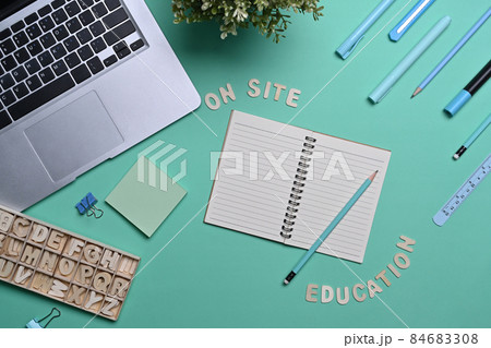 Above view laptop computer and various stationery on green background. Above view laptop computer and various stationery on green background. 84683308