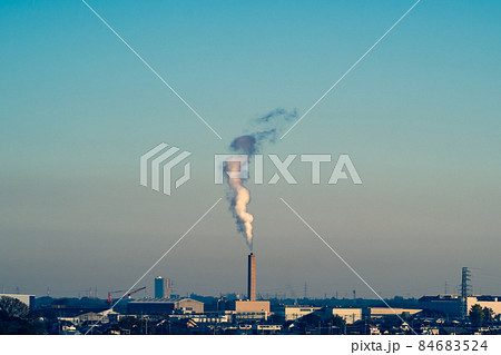 朝の青空と工場の煙突から立ち上る煙　シアン色 84683524