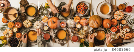 Hands of people eating pumpkin soup over 84685666