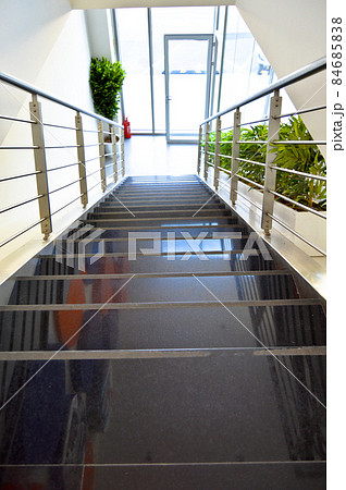 Black granite stairs and decorative chrome metal railings in a modern house Black granite stairs and decorative chrome metal railings in a modern house 84685838