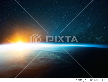 Beautiful blue planet earth in outer space on background of stars and milky way with sunrise. Amazing yellow sunset from space. World with sunlight 84686017