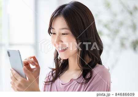 部屋着を着てスマホを操作する女性 部屋着を着てスマホを操作する女性 84686609