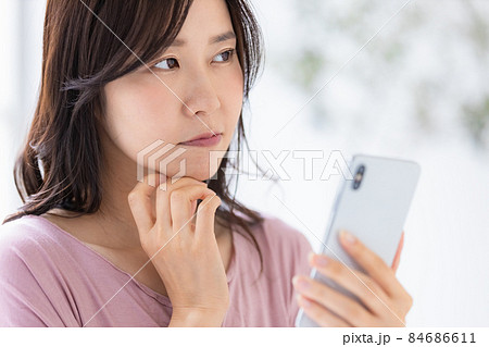 部屋着を着てスマホを操作する女性 84686611