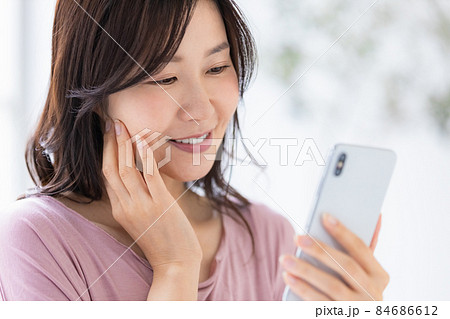 部屋着を着てスマホを操作する女性 部屋着を着てスマホを操作する女性 84686612