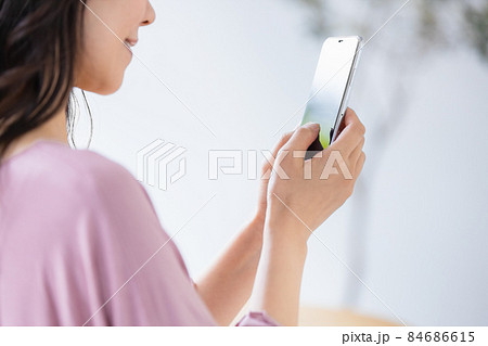 部屋着を着てスマホを操作する女性 84686615