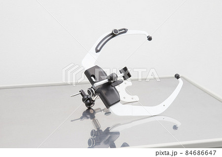 The face bow used in dentistry lies on the table. Orthopedic instrument. Modern technologies Close-up The face bow used in dentistry lies on the table. Orthopedic instrument. Modern technologies Close-up 84686647