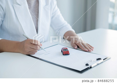 The hands of the real estate agent draw up an agreement, contractual documents on car loans The hands of the real estate agent draw up an agreement, contractual documents on car loans 84688255