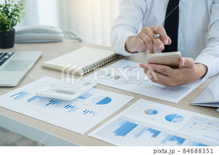 The businessman hand sits at their desks and calculates financial graphs showing the results of their investments planning the process of successful business growth 84688351