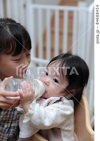 赤ちゃんにミルクを飲ませるお姉ちゃん 赤ちゃんにミルクを飲ませるお姉ちゃん 84688454