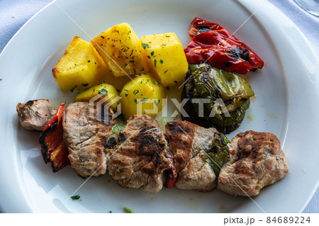 Greek souvlaki kebap with grilled tomatoes. 84689224