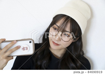 スマホを持ったニット帽とメガネの女性の写真素材 [84690919] - PIXTA