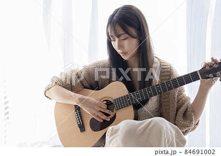 ギターを弾く女性 84691002