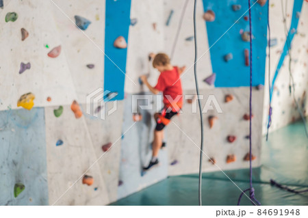 Boy at the climbing wall without a helmet, danger at the climbing wall Boy at the climbing wall without a helmet, danger at the climbing wall 84691948