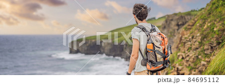 BANNER, LONG FORMAT Male tourist on the background of beautiful rocks and the sea. Hiking concept. Tobizin cape. Vladivostok, island Russky. Sea of Japan. Primorye. Primorsky krai. Nature of Russia 84695112