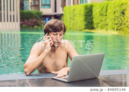 Young freelancer working on vacation next to the swimming pool 84695146