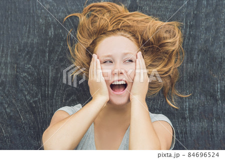 Top view of a young woman with space for text and symbols on the old wooden background. Concept for confusion, brainstorming and choice 84696524