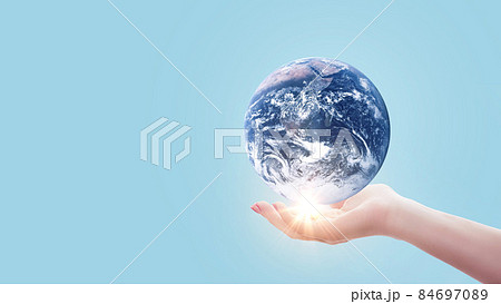 Hand holds blue planet Earth with sunset light on pastel blue color. Save Earth concept. Environment creative idea 84697089