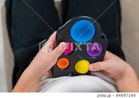 Faceless caucasian little boy plays simple dimple and relieves stress. Faceless caucasian little boy plays simple dimple and relieves stress. 84697169