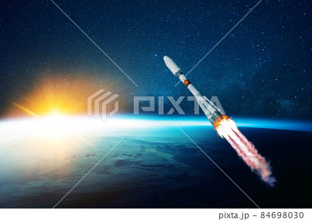 space rocket flies in the starry sky over the amazing blue planet earth and yellow sunset. Spaceship with blast flies into outer space. Travel to other planets concept. Successful start space rocket flies in the starry sky over the amazing blue planet earth and yellow sunset. Spaceship with blast flies into outer space. Travel to other planets concept. Successful start 84698030