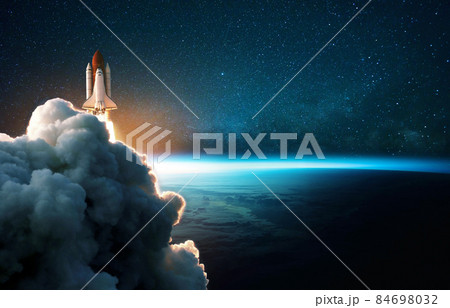 Space rocket lift off into cosmos with smoke and blast on a background of the blue planet earth. Spacecraft flies in space with a starry sky near the planet. Successful start of the mission 84698032