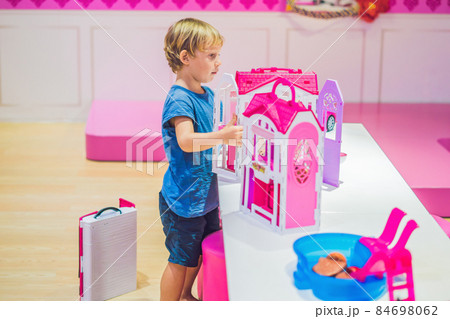 The boy plays with girl toys and dolls The boy plays with girl toys and dolls 84698062