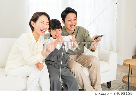 ゲームを楽しむ親子3人のファミリー ゲームを楽しむ親子3人のファミリー 84698159