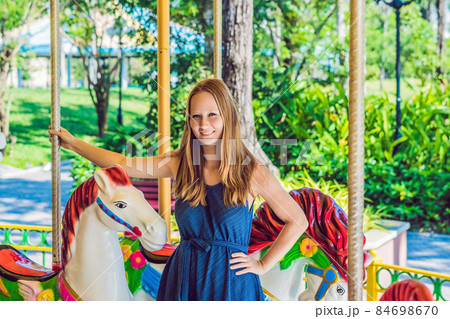Woman enjoying in funfair and riding on colorful carousel house 84698670