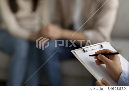 Marital counselor taking notes at therapy session with arab couple, talking with couple at marriage counseling meeting Marital counselor taking notes at therapy session with arab couple, talking with couple at marriage counseling meeting 84698820